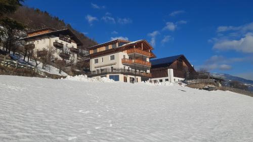 a building on top of a snow covered hill at Frühaufhof in Barbiano