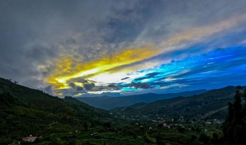 einen wolkigen Himmel mit einer Stadt in der Ferne in der Unterkunft Warmth Hill Crest in Kodaikanal