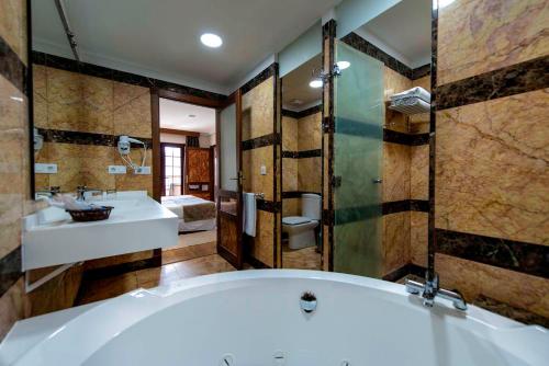 a large bathroom with a tub and a sink at Paradise Park Fun Lifestyle Hotel in Los Cristianos