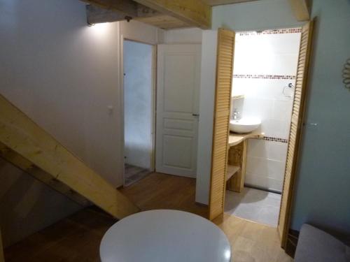 La salle de bains est pourvue d'une table blanche et d'un lavabo. dans l'établissement chambre campagnarde, à Bargème