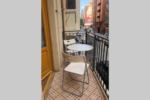 a balcony with two chairs and a table on a balcony at Acogedor apartamento en Ruzafa-centro in Valencia