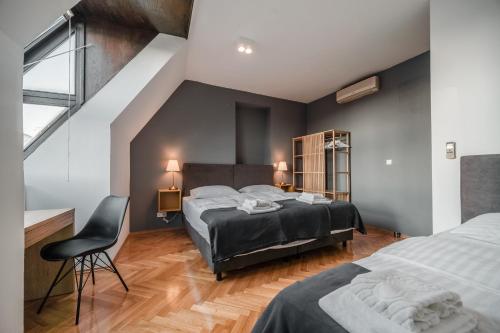 una camera con due letti e una sedia di Lux Apartments a Zagabria