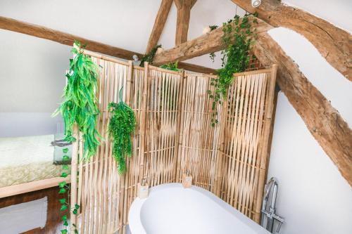 ein Badezimmer mit einer Holzwand mit Efeu in der Unterkunft Au Zen Garden in Auxerre