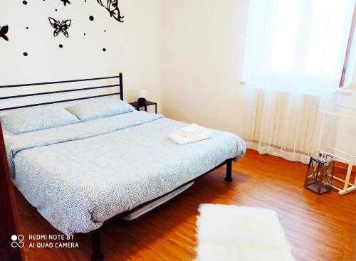 a bedroom with a bed with a blue comforter at Casa Sorriso in Bergamo