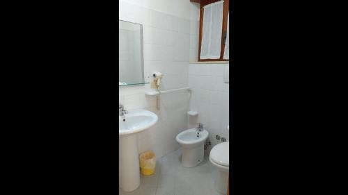 łazienka z umywalką, toaletą i lustrem w obiekcie Room in BB - Spacious double room by the sea w mieście Pineto