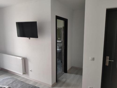 a room with a flat screen tv on a wall at Pensiunea Teodora in Moisei