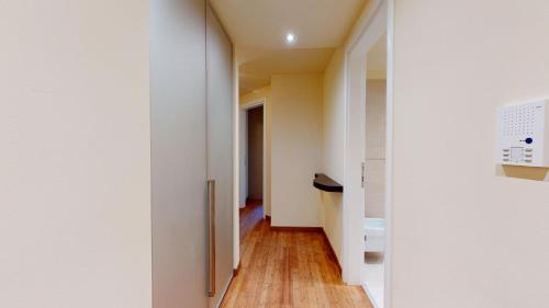 a hallway with white walls and a wooden floor at Chesa Seraina Abitaziun Seraina 3 - Cream - Madulain in Madulain