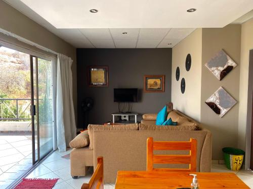 sala de estar con sofá y TV en Glenvista Home with a View, en Johannesburgo