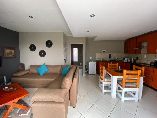 uma sala de estar com um sofá e uma mesa em Glenvista Home with a View em Joanesburgo