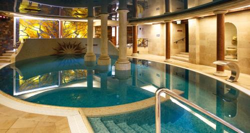a swimming pool in a building with a swimming pool at Meduza Hotel & Spa in Mielno