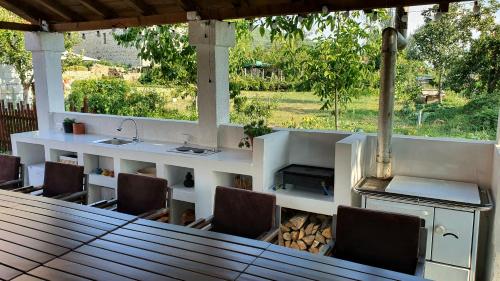 cocina al aire libre con barra, sillas y mesa en Villa Prespa, en Dolno Dupeni