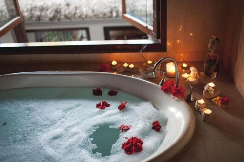 een bad met rode bloemen en een raam bij Magical Pumpkin Secret Garden leisure hotel in Okayama