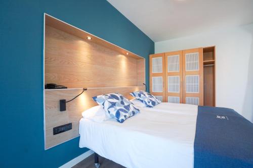 ein Schlafzimmer mit einem großen weißen Bett mit blauen Wänden in der Unterkunft Playitas Hotel - Sports Resort in Las Playitas