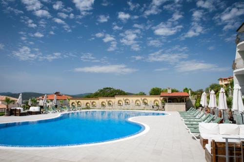 une piscine dans un complexe hôtelier avec chaises et parasols dans l'établissement Gardenia Vacation Settlement, à Sozopol