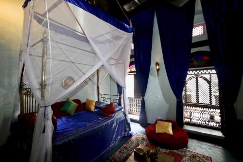 a bedroom with a canopy bed in a room at Emerson on Hurumzi in Zanzibar City