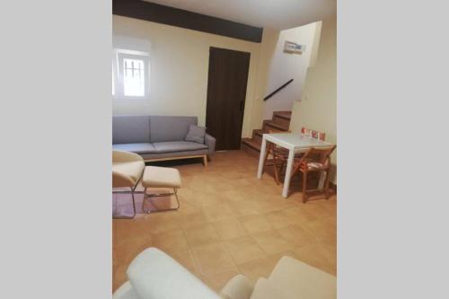ein Wohnzimmer mit einem Sofa und einem Tisch in der Unterkunft Casa Abuelo Lorenzo in Enguídanos