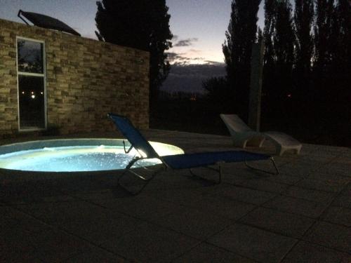 a swimming pool with two chairs and a lounger at Finca La Celestita in Colonia Alvear