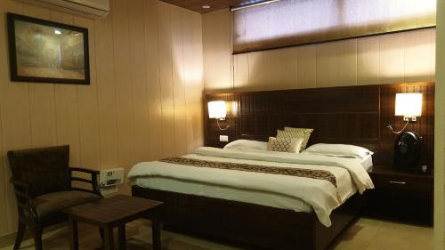 克勒尔Maple Leaf Hotel的配有一张大床和一把椅子的酒店房间