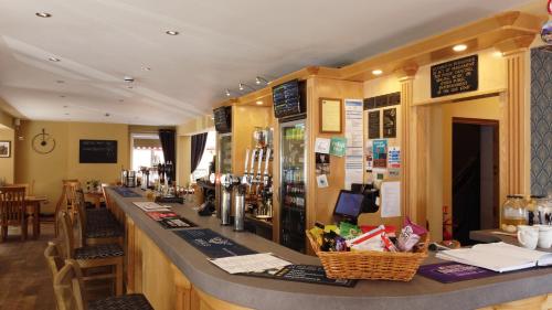 eine Bar in einem Restaurant mit einer Arbeitsplatte in der Unterkunft The White Hart in Ashill