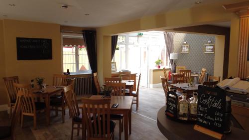 a restaurant with wooden tables and chairs and a window at The White Hart in Ashill