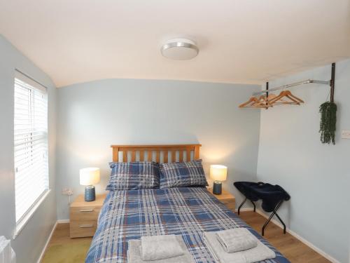 a bedroom with a bed with two lamps and two pillows at Clydfan in Caernarfon