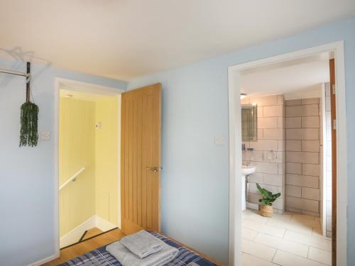 a bedroom with a bed and a bathroom with a shower at Clydfan in Caernarfon