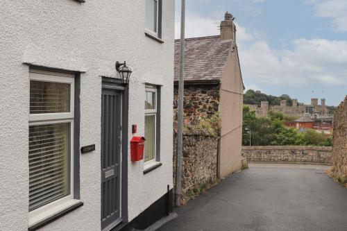 a white house with a red mailbox on the side of it at Clydfan in Caernarfon