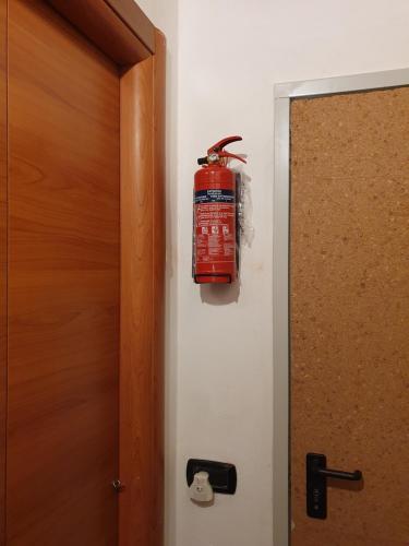 a fire extinguisher hanging on a wall next to a door at Dora Baltea in Verona