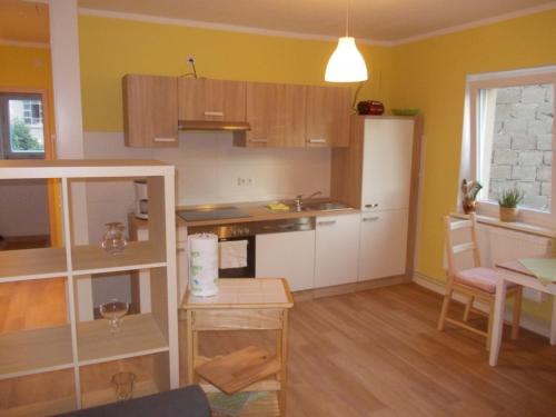 una cocina con paredes amarillas, una mesa y una habitación en Schwalbennest - 93355, en Marlow
