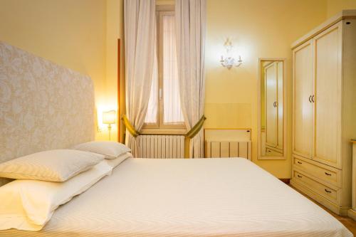 a bedroom with a white bed and a window at Domus Pinciana in Rome