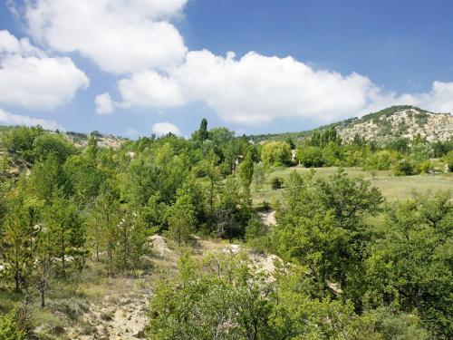 a view of a field with trees and mountains at Les Maisons De Chante Oiseau in Sigonce