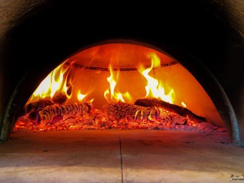 a large brick oven with fire in it at Les Maisons De Chante Oiseau in Sigonce