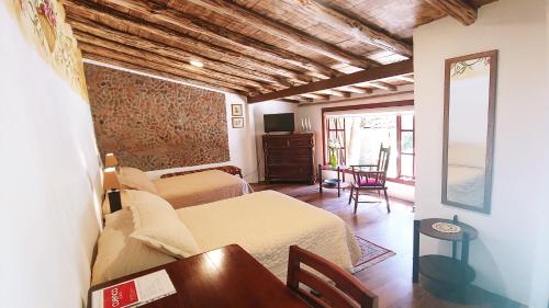 a bedroom with a bed and a table in a room at Hotel Boutique Casa Montalvo Cuenca in Cuenca