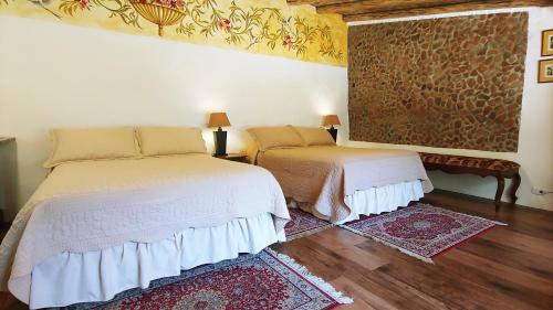 a bedroom with two beds and a painting on the wall at Hotel Boutique Casa Montalvo Cuenca in Cuenca