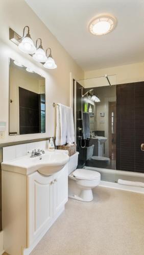 a bathroom with a sink and a toilet and a mirror at Bayview Pines Country Inn B&B in Mahone Bay