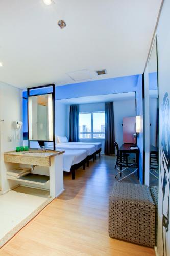 a hotel room with a bed and a mirror at ibis Styles Goiania Marista in Goiânia