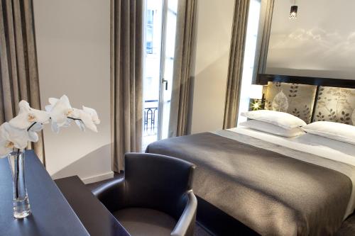 a hotel room with a bed and a chair at Hôtel Caron le Marais in Paris