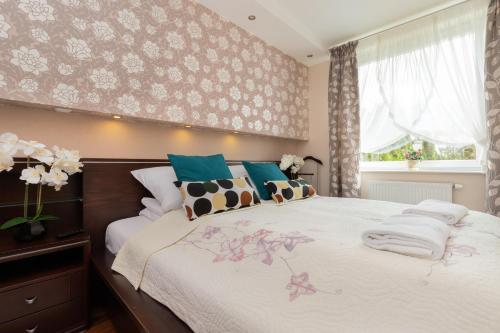 um quarto com uma cama grande com flores na parede em Apartment Trzy Żagle Gdańsk by Renters em Gdansk