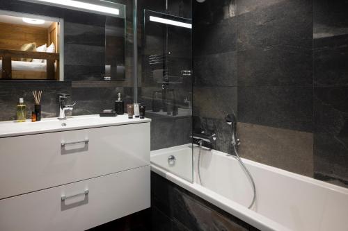 a bathroom with a tub and a sink and a shower at Hôtel Ski Lodge - Chambres & Appartements - Village Montana in Val dʼIsère