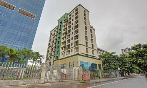 un edificio alto con una valla delante en Treebo Trend Welcome Apartments, en Bombay