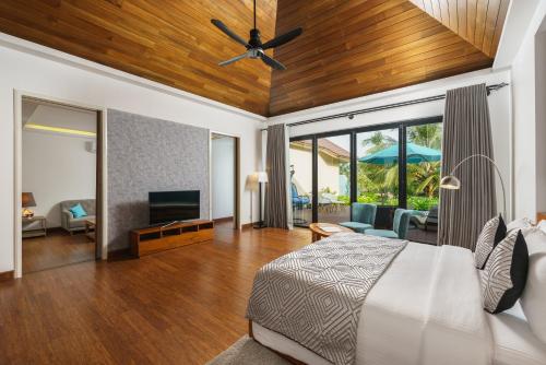 - une chambre avec un lit et un ventilateur de plafond dans l'établissement Aprota Villas Arugambay, à Baie d'Arugam