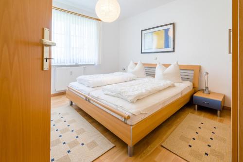 a bedroom with a bed with white sheets and pillows at Friedenstraße 21 Whg 1 in Zingst