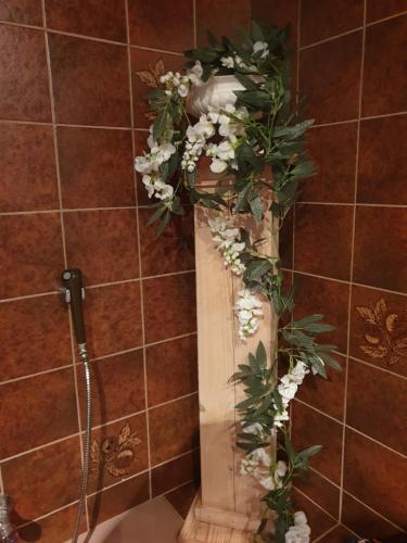 a shower with a pillar with flowers in a bathroom at Westert Hoeve in Vriescheloo