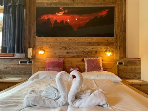 two swans are laying on a bed at Villa Anita San Vigilio di Marebbe in San Vigilio Di Marebbe