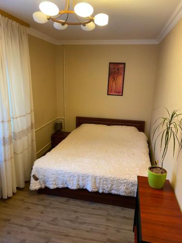 1 dormitorio con cama y lámpara de araña en Апартаменти en Chernihiv