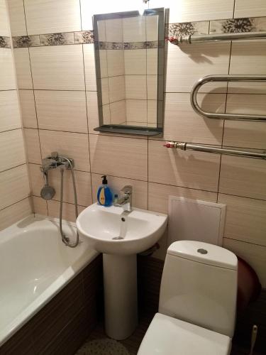 y baño con lavabo, aseo y bañera. en Апартаменти, en Cherníhiv