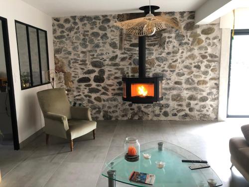 a living room with a glass table and a fireplace at L 'Air d'Aspe in Accous