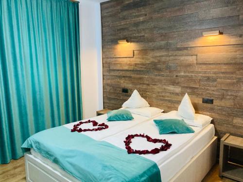 a bedroom with a bed with two hearts on it at Sim House in Gura Humorului