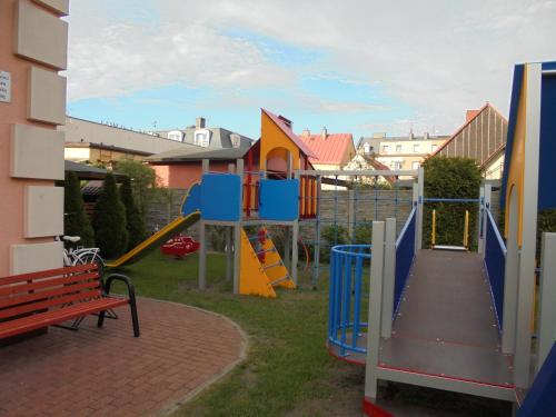a park with a playground with a slide and a bench at Villa Sovita in Łeba