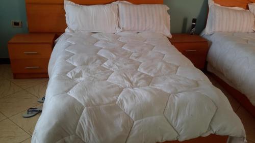 biała kołdra na łóżku w pokoju w obiekcie Pure Pension w Addis Abebie